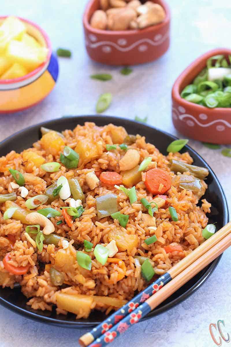 Classic and Exotic with tropical flavors - Thai Pineapple Fried Rice Recipe - Lovely blend of sweet- savory flavors and its Truly Heavenly. This Vegan Pineapple Fried rice preparation is a little bit spicy, tangy and sweet. Make it as the main course or as a side dish to any meal over the weekend. Thai Pineapple Fried rice is always a favorite.