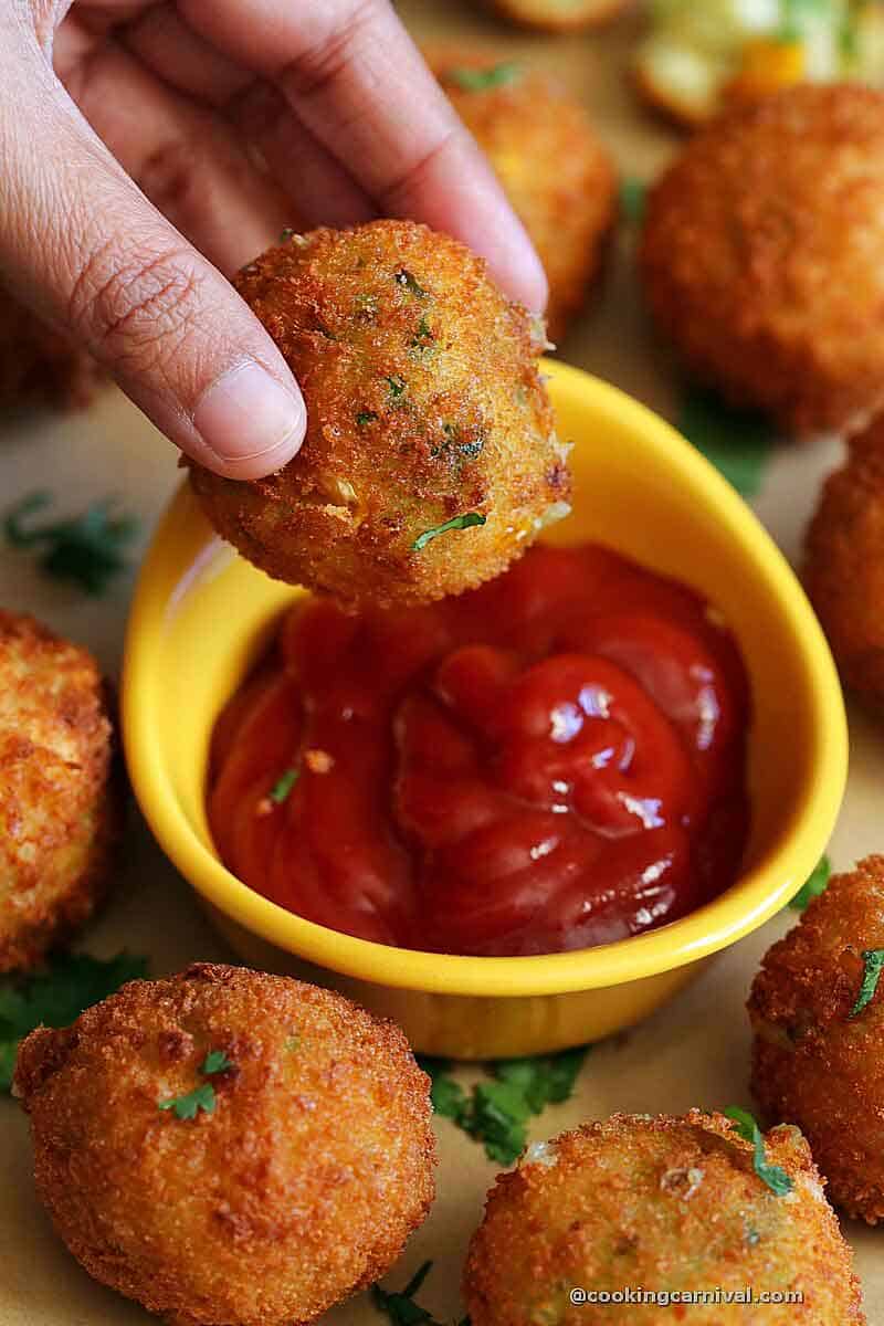 Dipping Cheese corn balls in tomato ketchup