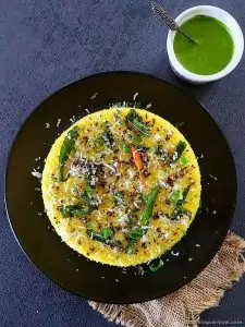 Dhokla with tempering on top, green chutney on the side