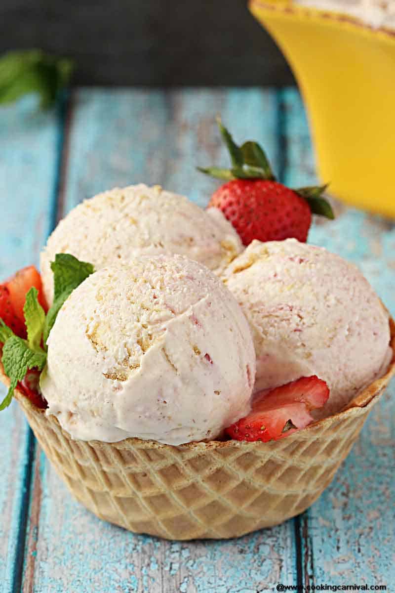 Homemade Strawberry Cheesecake Ice Cream - Creamy Ice cream Base with cream cheese and a Strawberry Sauce and Roughly Crushed Graham crackers swirled throughout. Its Dreamy, Creamy and one of the most delicious Homemade Ice cream I have made!