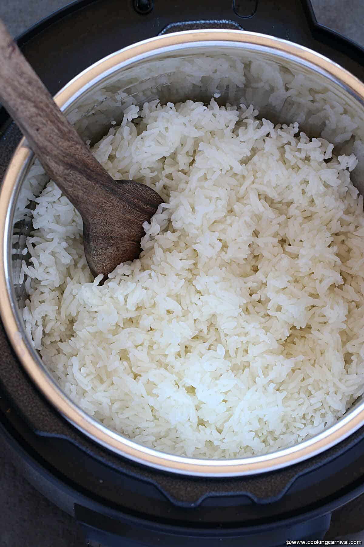 Jasmine rice in instant pot with wooden spatula