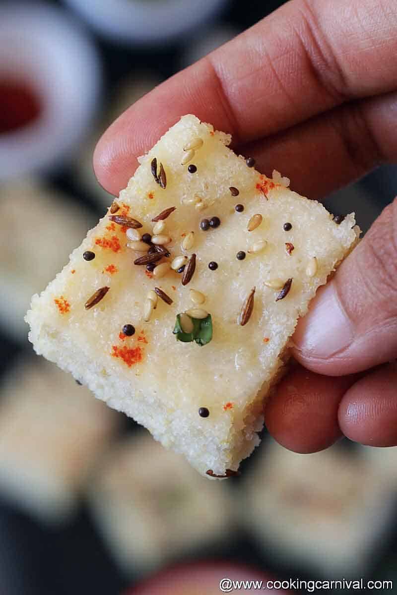 Holding white dhokla piece with hand