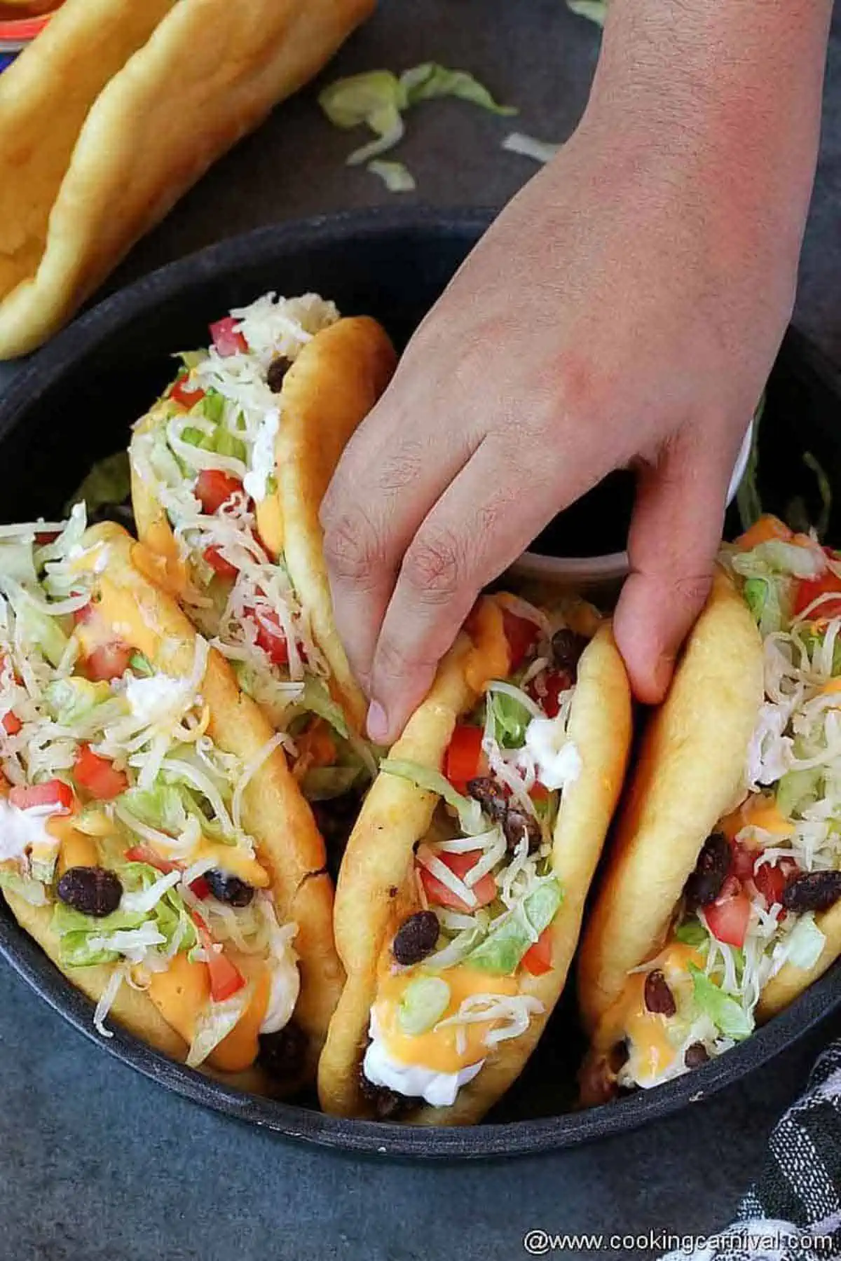 Grabbing one homemade chalupa from the plate.