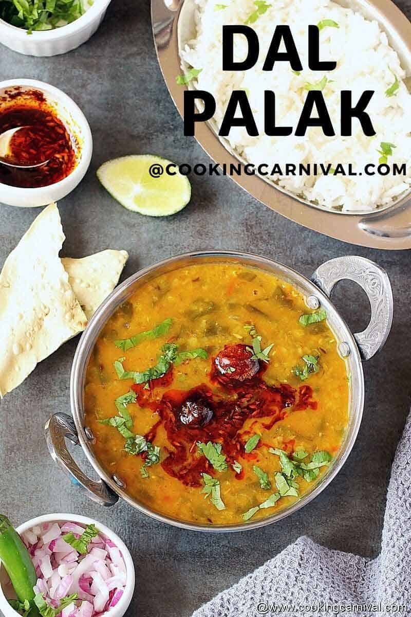 Dal palak in a bowl, rice, papad, cilantro and chopped onion on the sides.