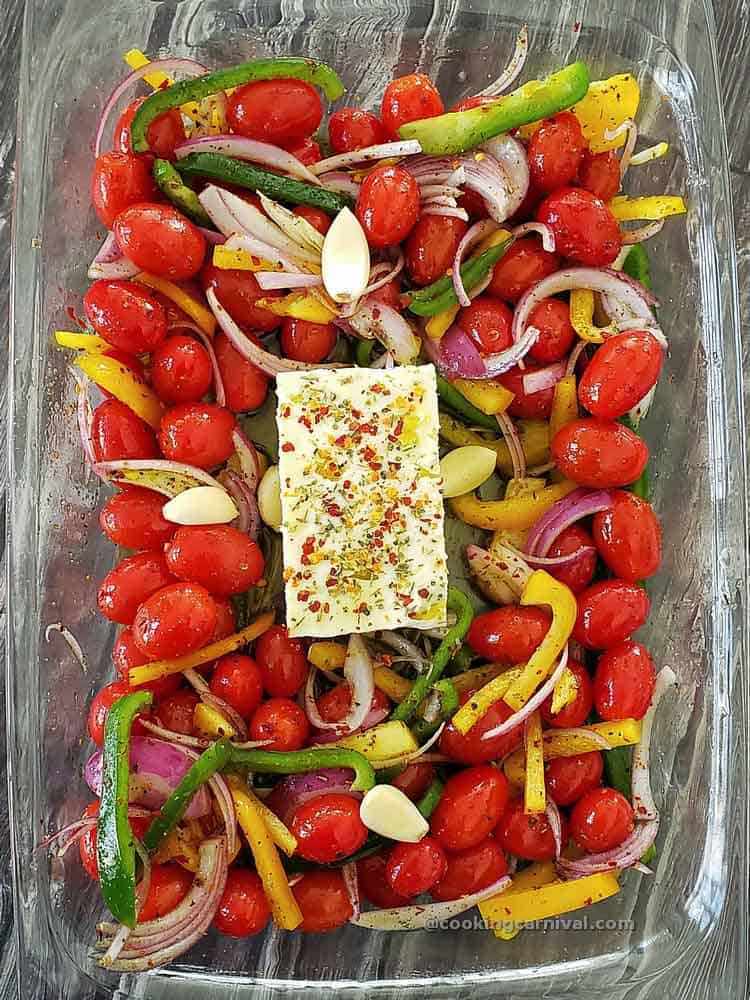 Cherry tomatoes, feta cheese, vegetables in a baking dish