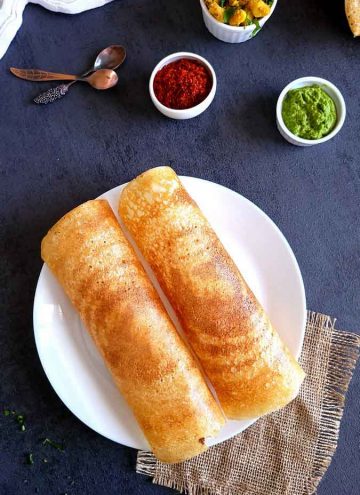 2 Instant dosa in a white plate, chutney, podi and potato masala on the side
