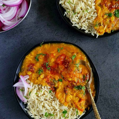Dal and rice in a black plate