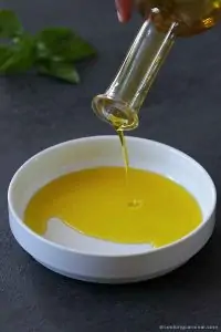 Pouring extra virgin olive oil a dipping plate