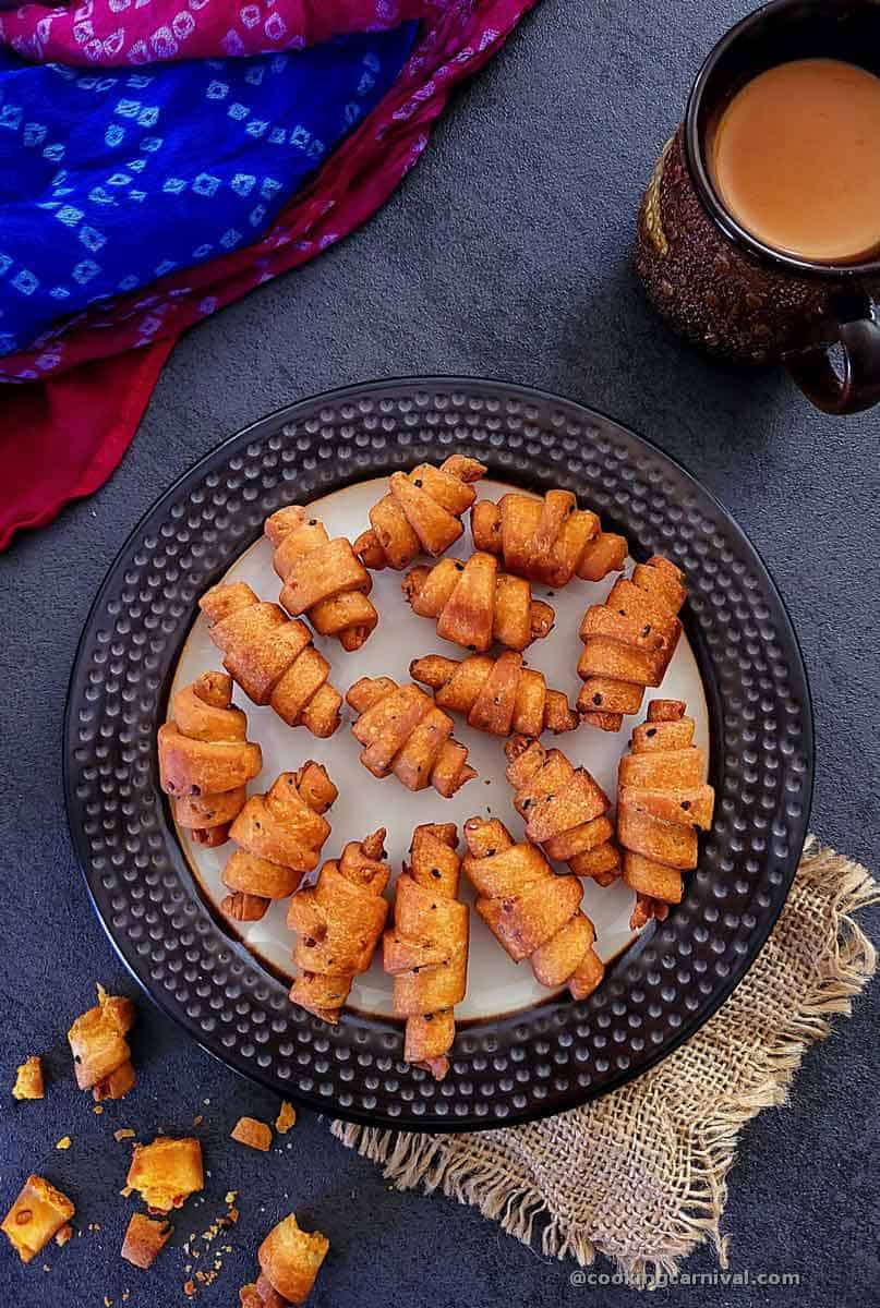 Schezwan mathri in a plate, masala tea on side