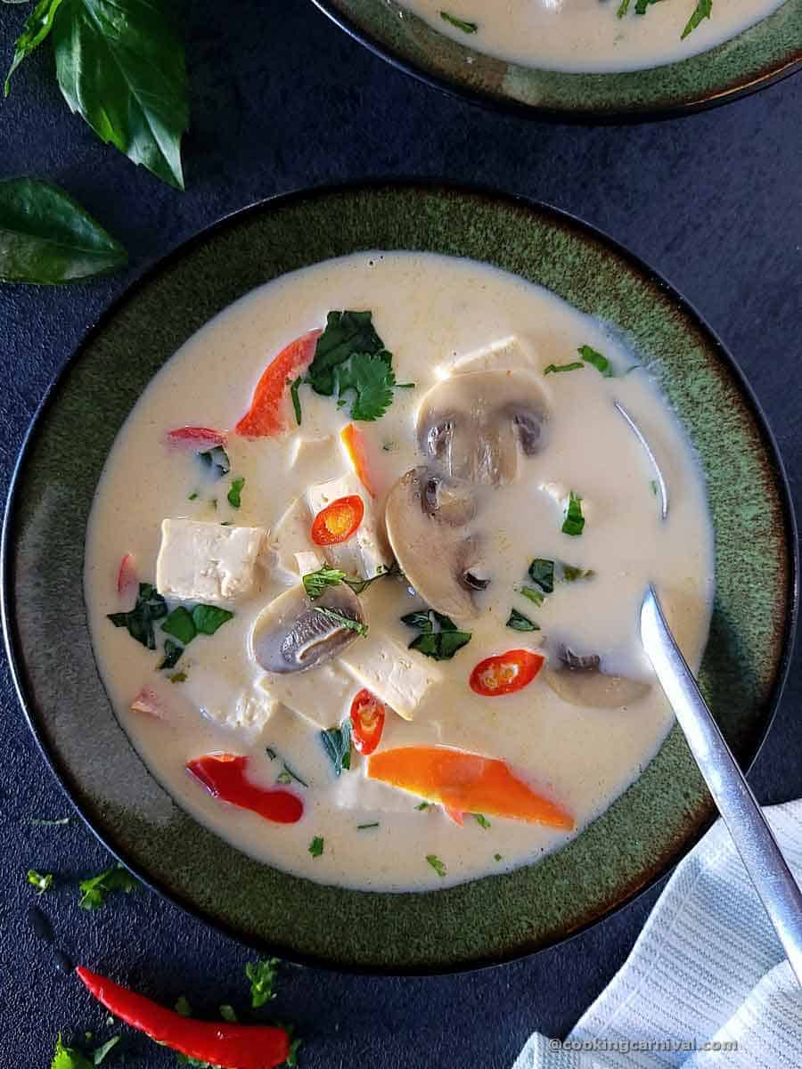 Tom Kha Soup in a bowl with spoon