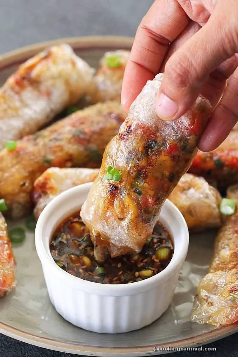dipping rice paper dumpling in a dipping sauce
