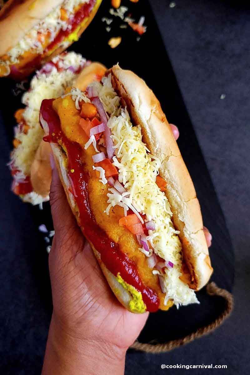 Holding veg hot dog in hand