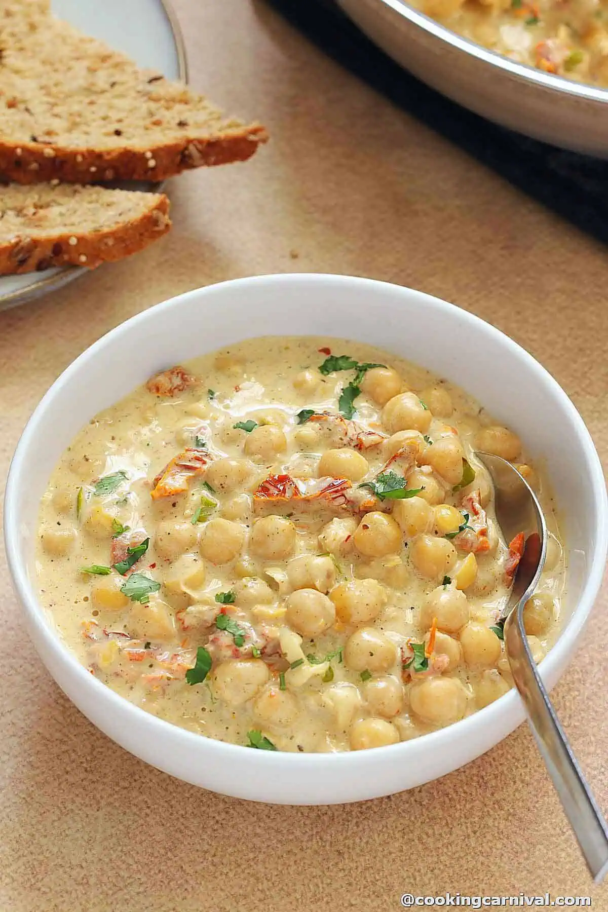 marry me chickpeas served in a white bowl, bread on a side.