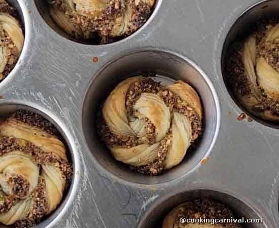 baked gujiya swirls in a baking pan.