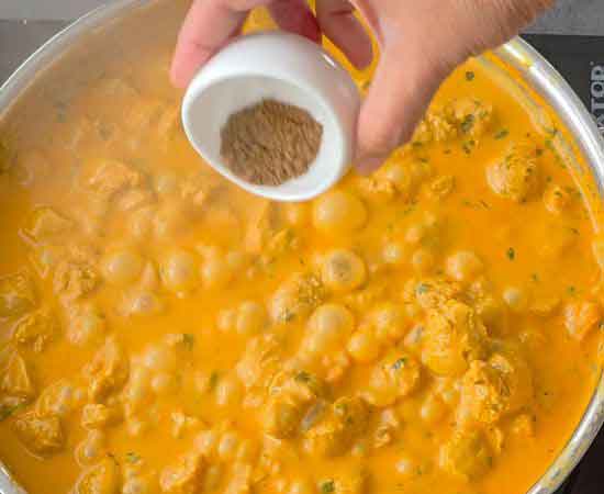 adding garam masala in soya chunks curry.