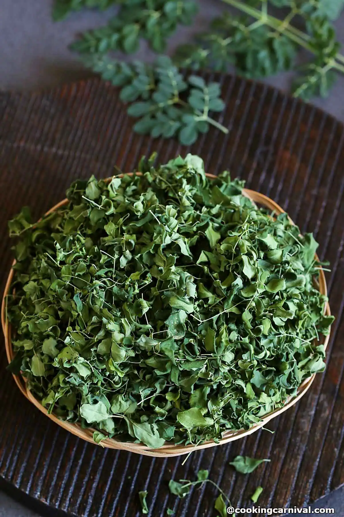 dry moringa leaves in a basket.