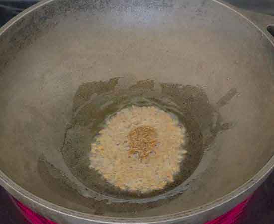 Adding cumin seeds in hot oil